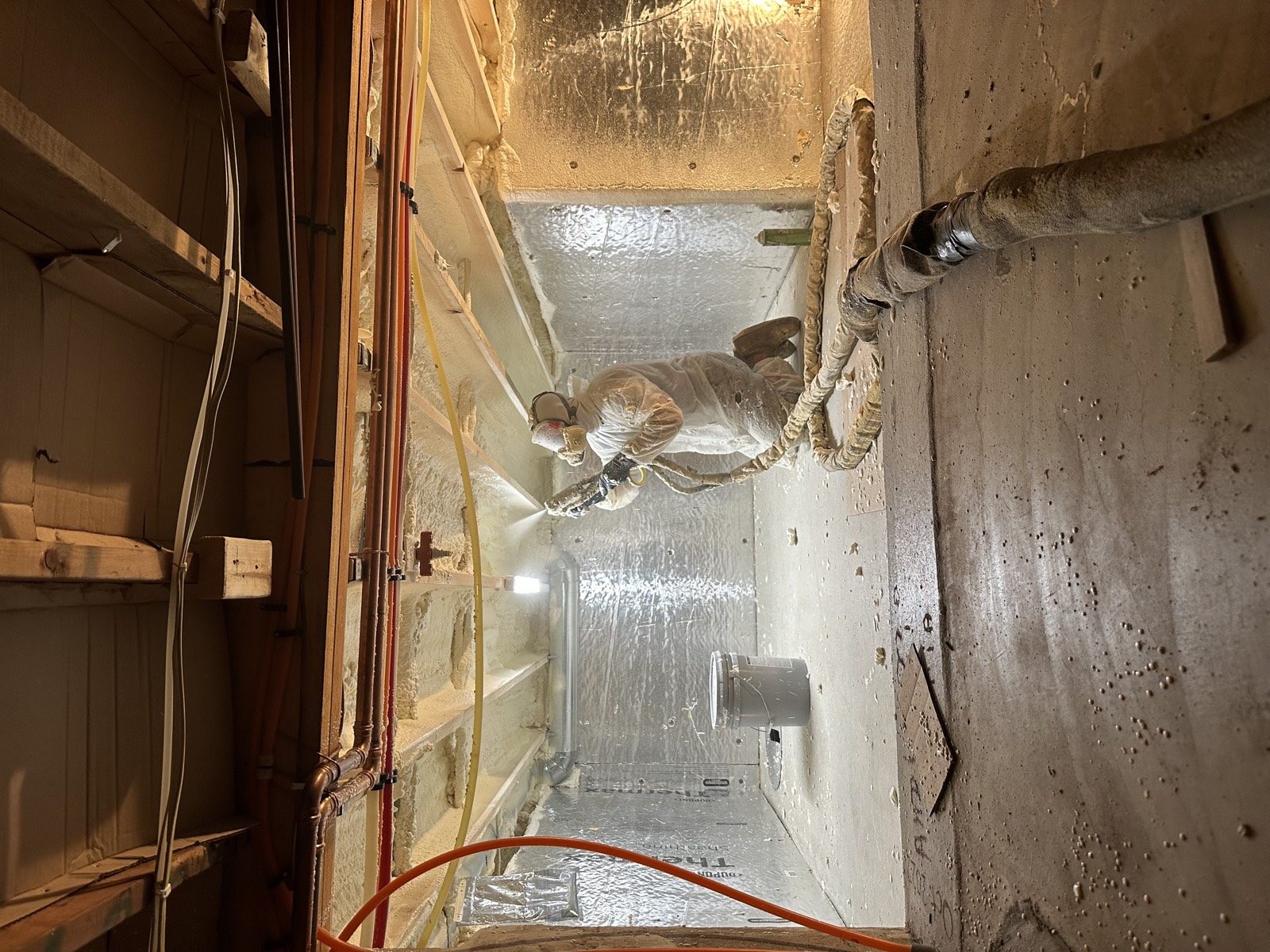 Spray foam being applied to a building cavity